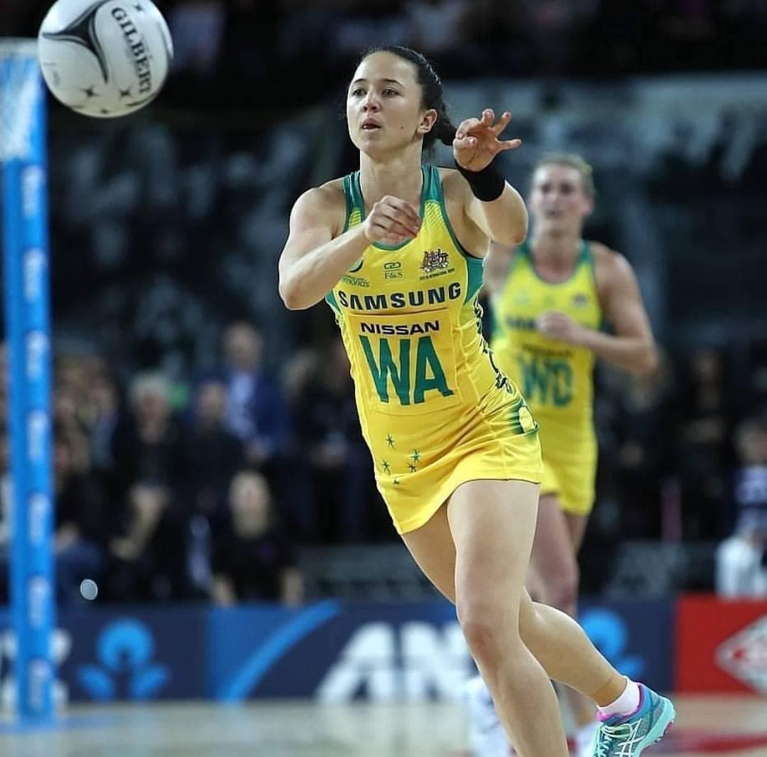 Caitlyn Strachan in the Australian Diamonds gold dress at Wing Attack, releasing a pass mid-court