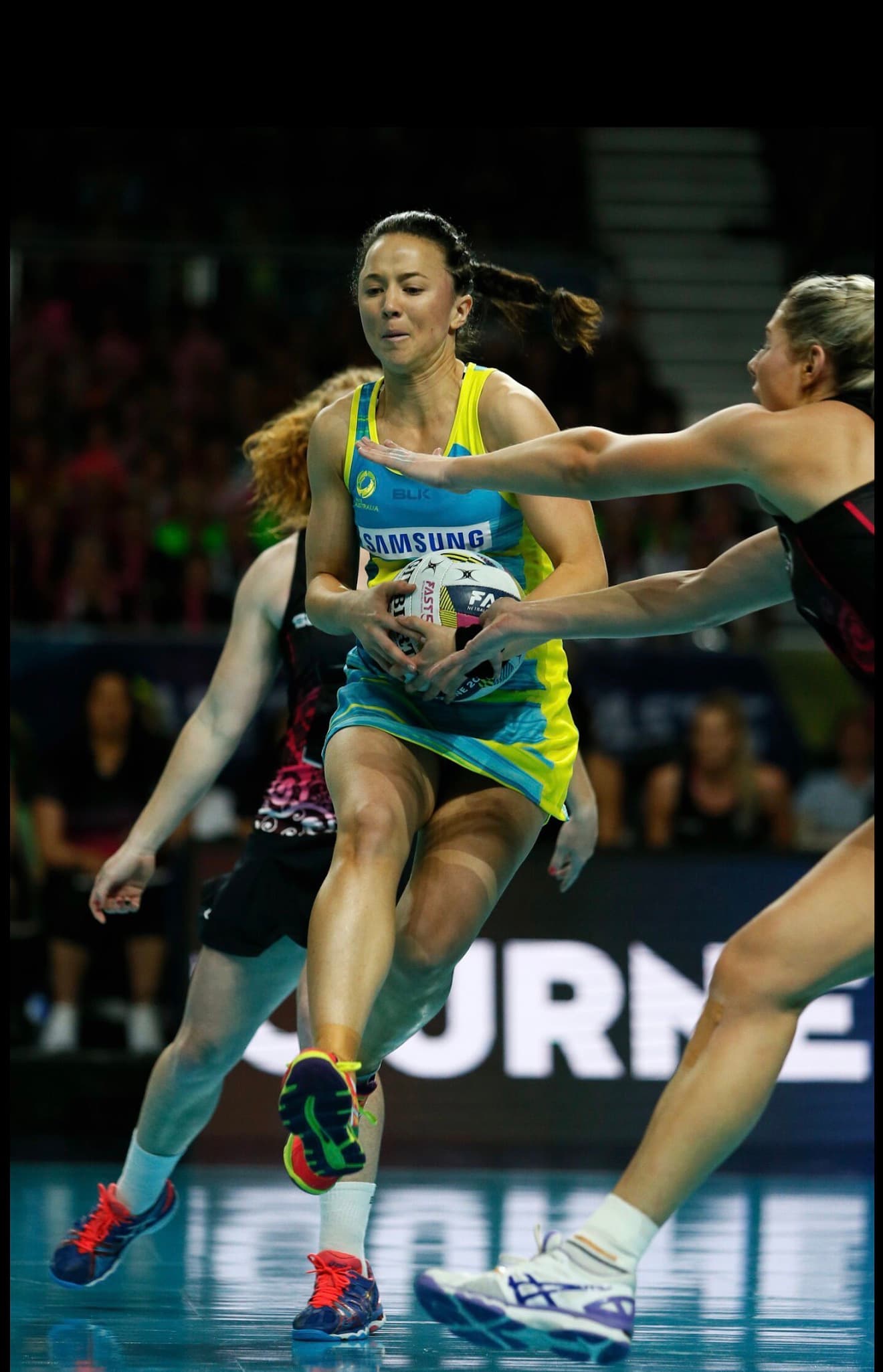 Caitlyn Strachan in the Diamonds Fast5 alternate kit landing under defensive pressure during a Fast5 World Series match in Melbourne.