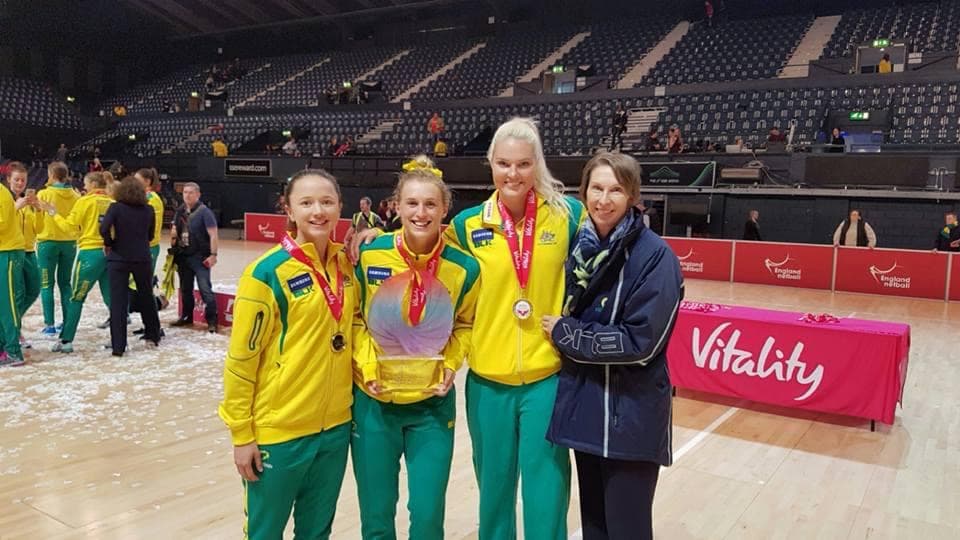 Caitlyn with Diamonds teammates and a coach holding the Vitality series trophy on tour in England.